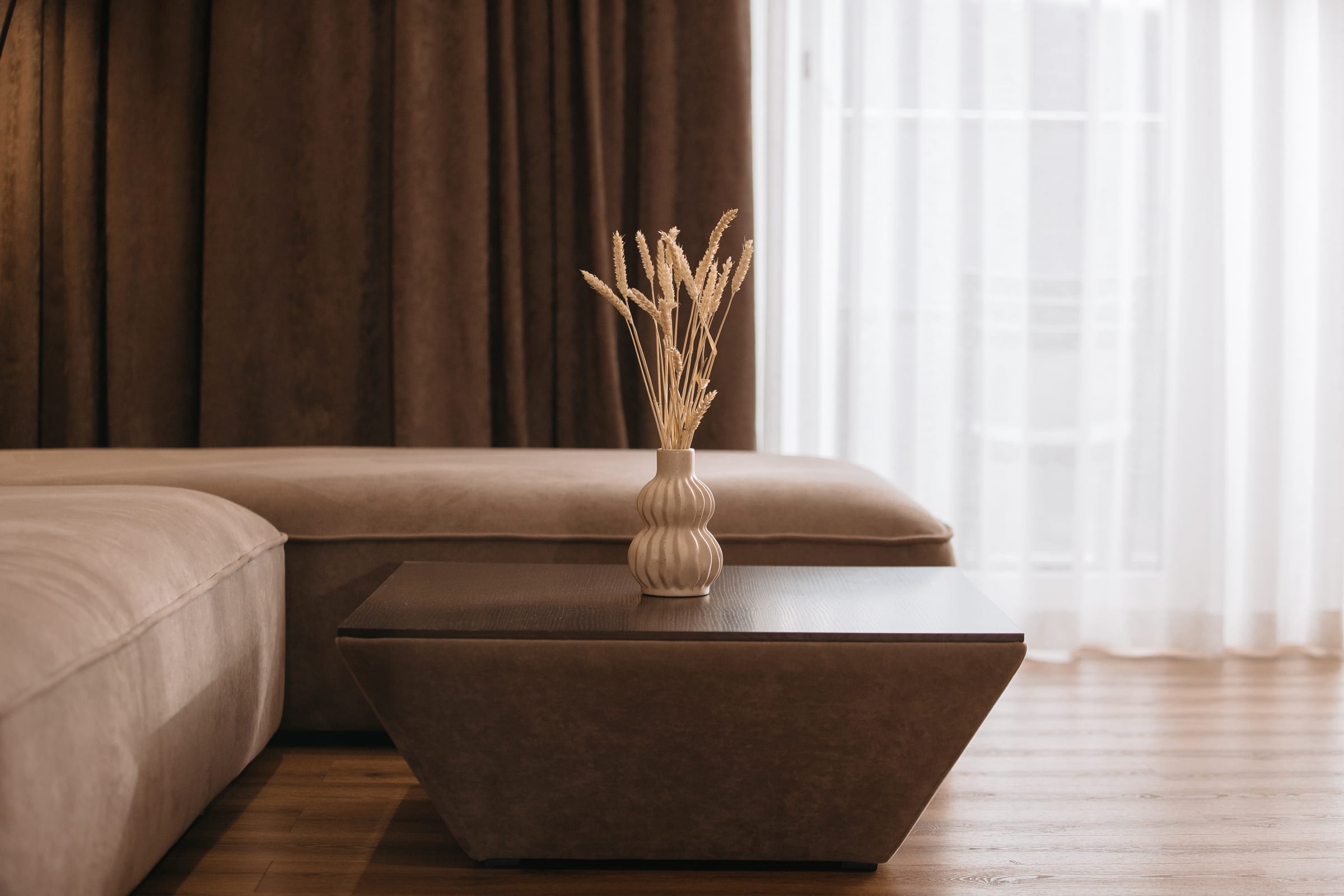Detalhe editorial em tons quentes com cortina chocolate e tecido aveludado