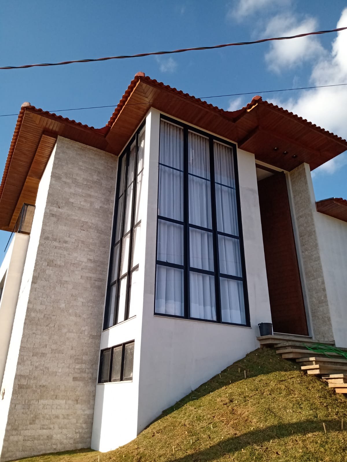 Sala com cortinas brancas e voil ao fundo, ambiente claro e minimalista