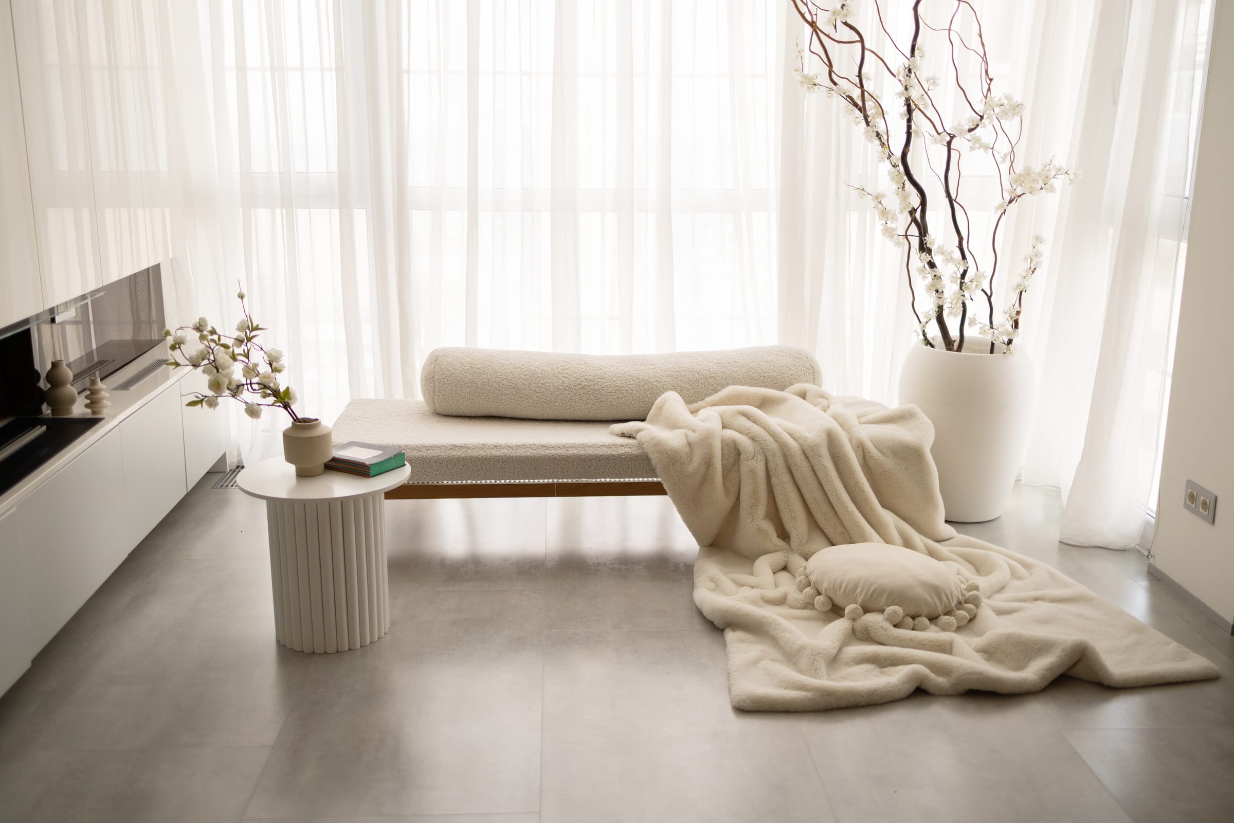 Voil branco esvoaçante junto a daybed creme em ambiente minimalista