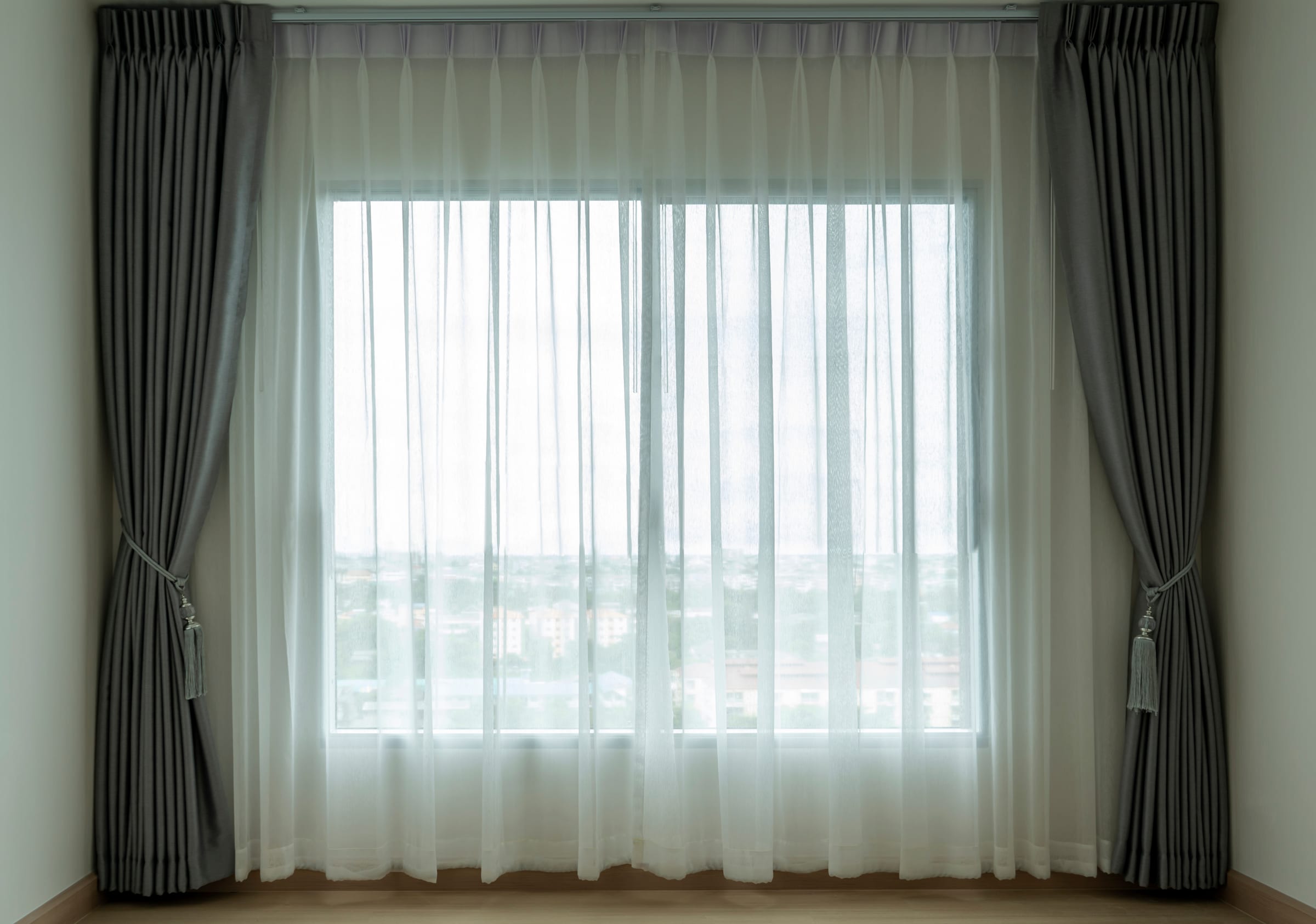 Cortinas em cinza grafite com voil branco em janela ampla